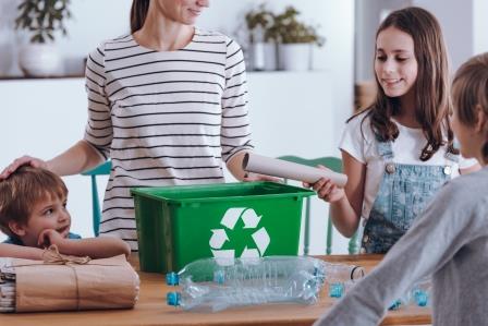 Mother teaching her children how to recycle