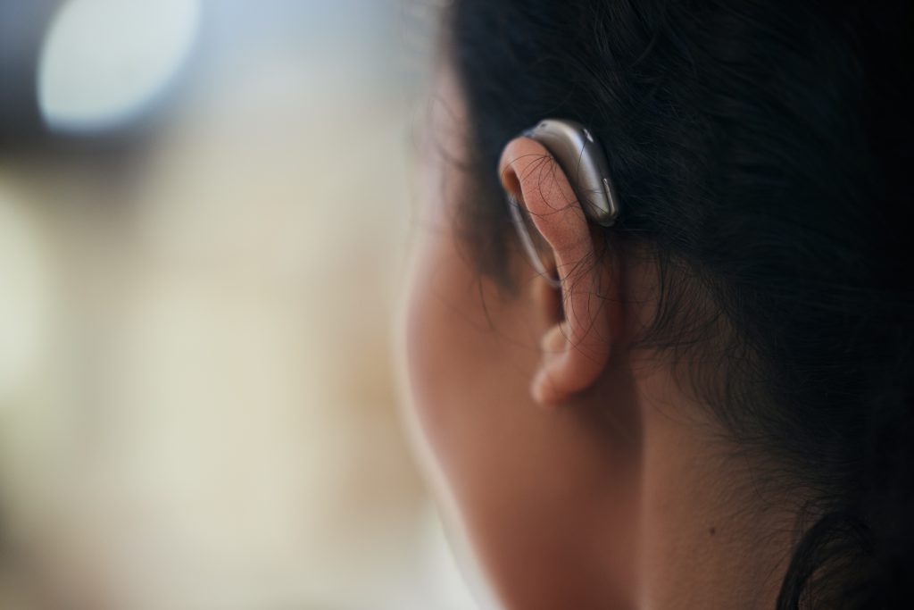 Hearing aid, closeup, and ear with a person with a disability for helping with audio and medical imp