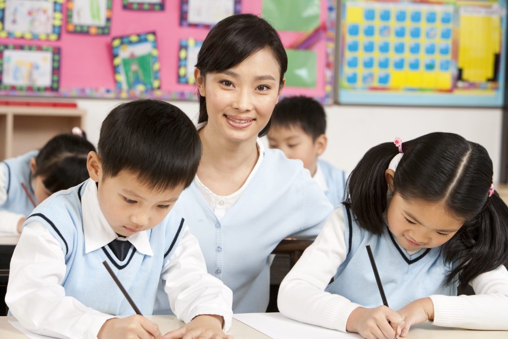 Teacher Assisting Students in Chinese Tuition Class