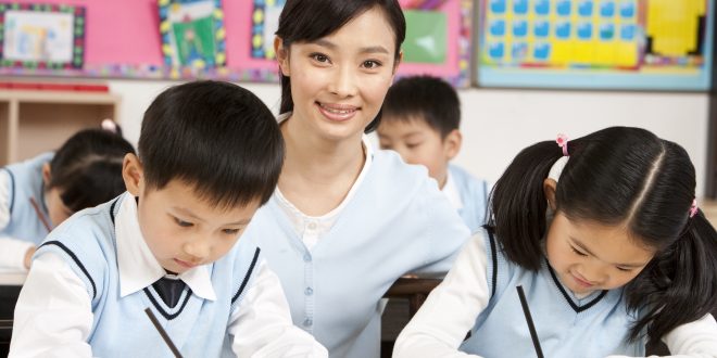 Teacher Assisting Students in Class