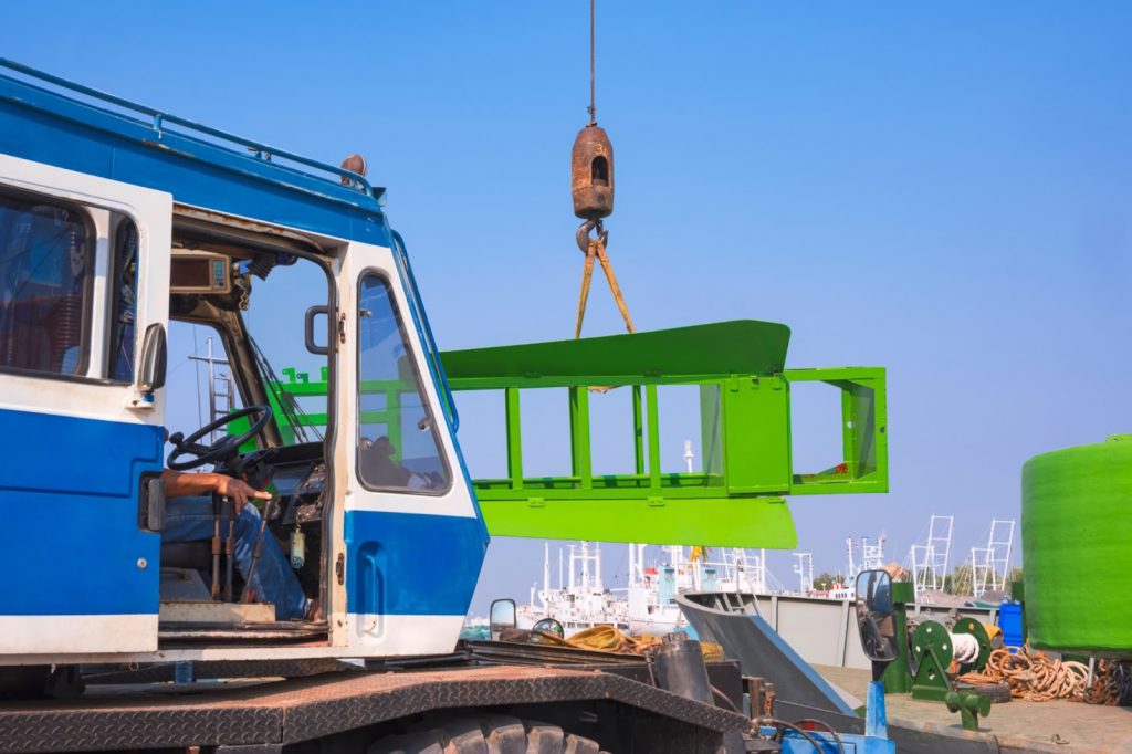 A crane lifting a construction material near a port