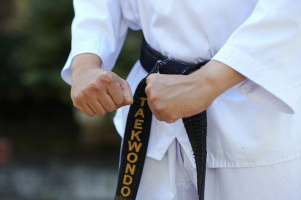 A student of a Taekwondo class wearing a black belt