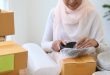 A woman packing a breakable parcel to be delivered to Malaysia