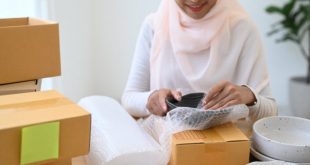 A woman packing a breakable parcel to be delivered to Malaysia