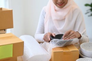 A woman packing a breakable parcel to be delivered to Malaysia