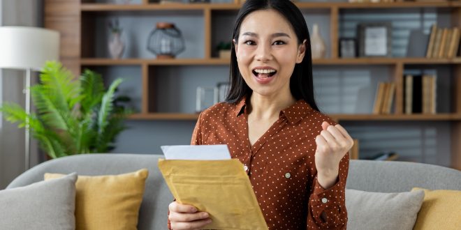 A woman happily holding a document envelope after successful delivery to Malaysia by Evermarch Logistics