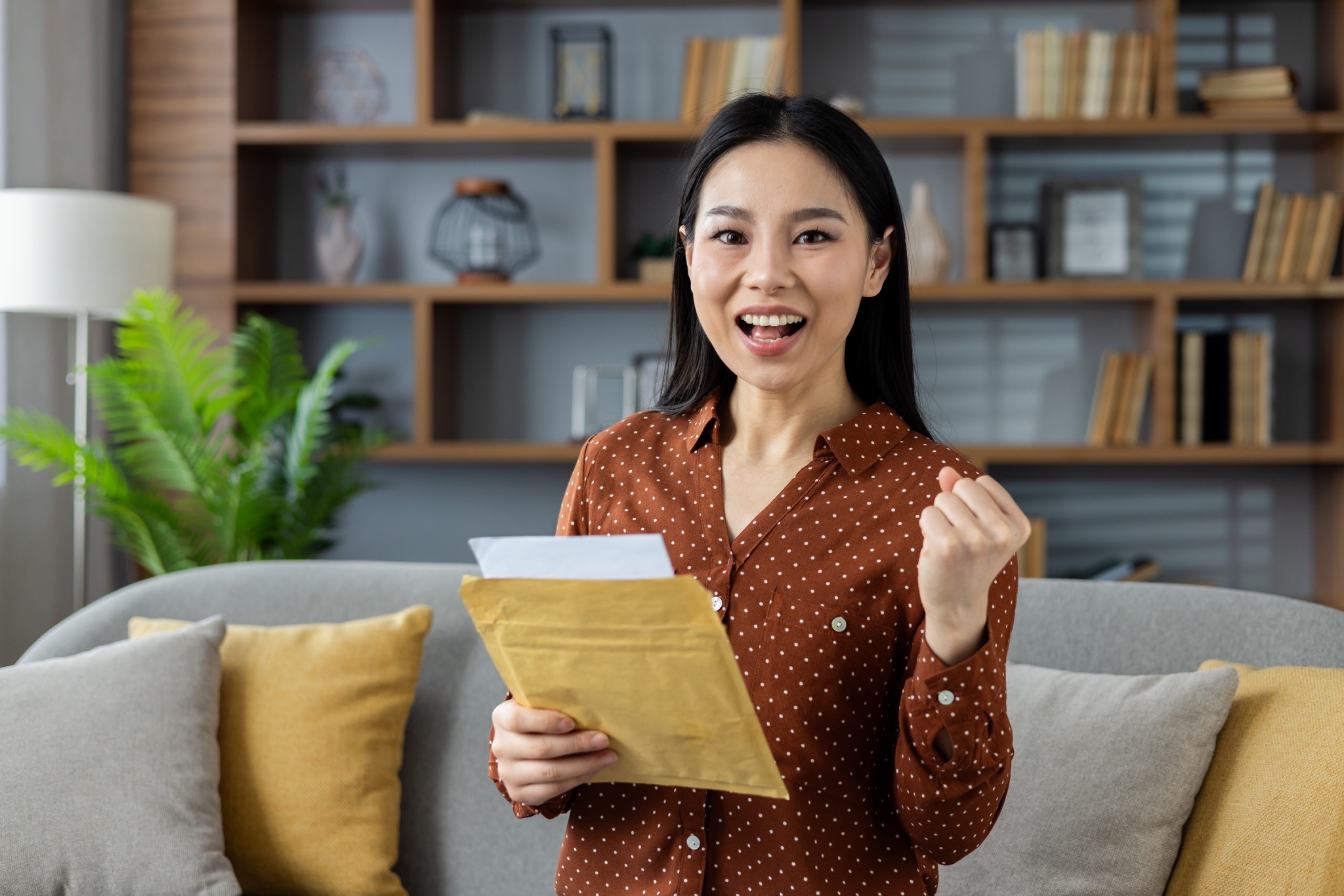 A woman happily holding a document envelope after successful delivery to Malaysia by Evermarch Logistics A woman happily holding a document envelope after successful delivery to Malaysia by Evermarch Logistics