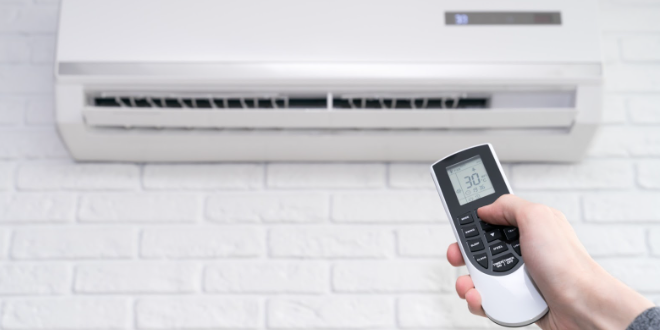 Adjusting air conditioner temperature with remote control – aircon installation Singapore