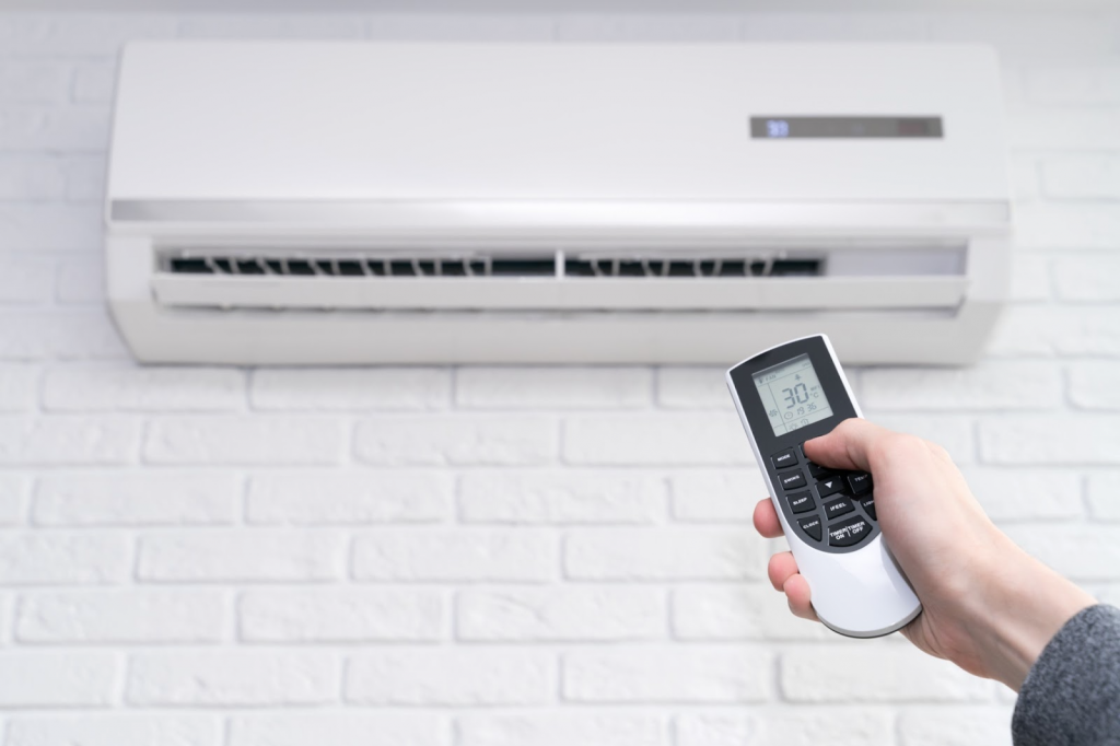 Adjusting air conditioner temperature with remote control – aircon installation Singapore
