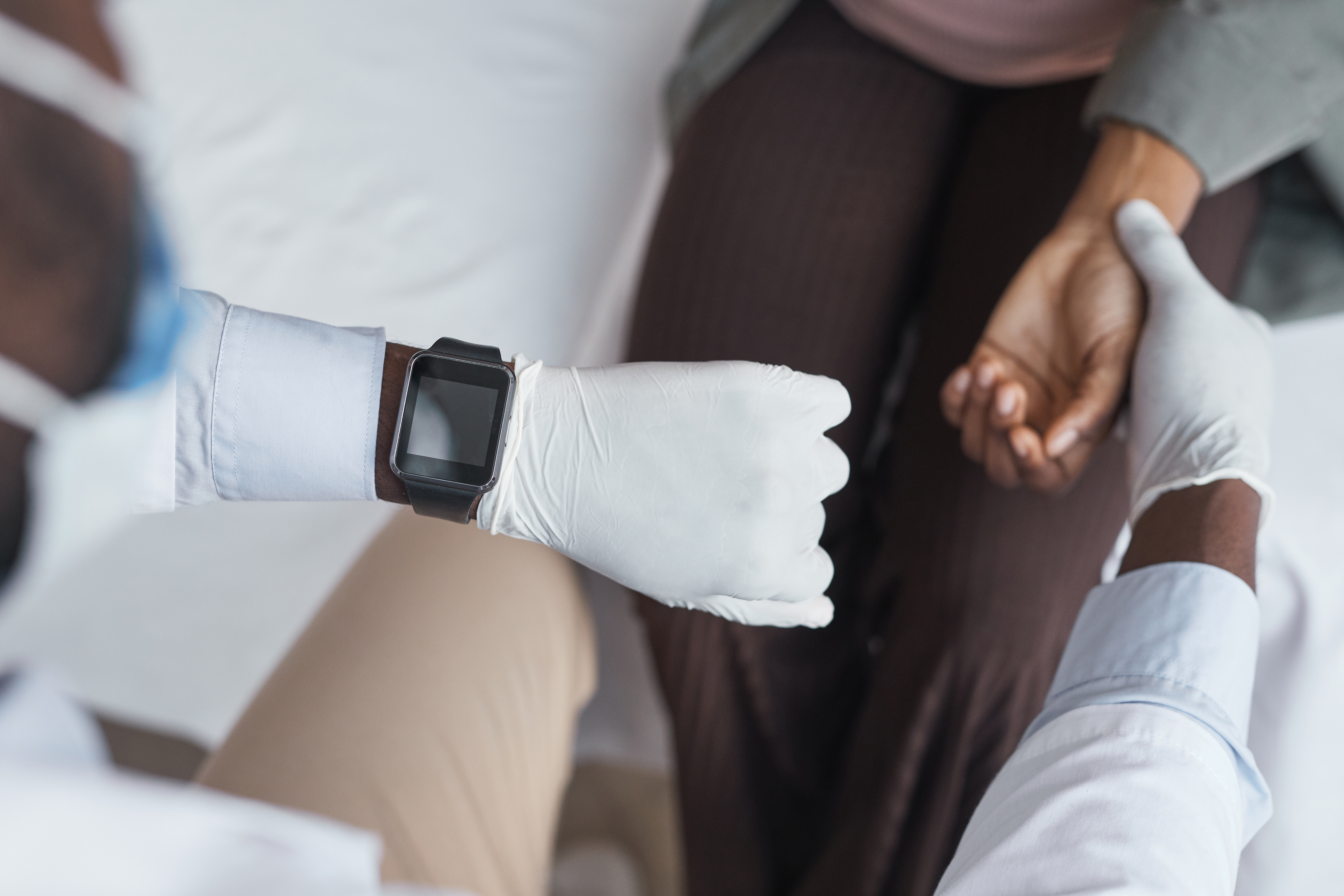 Doctor measuring patient pulse during consultation for persistent cough with phlegm at Orchard medical clinic CHI
