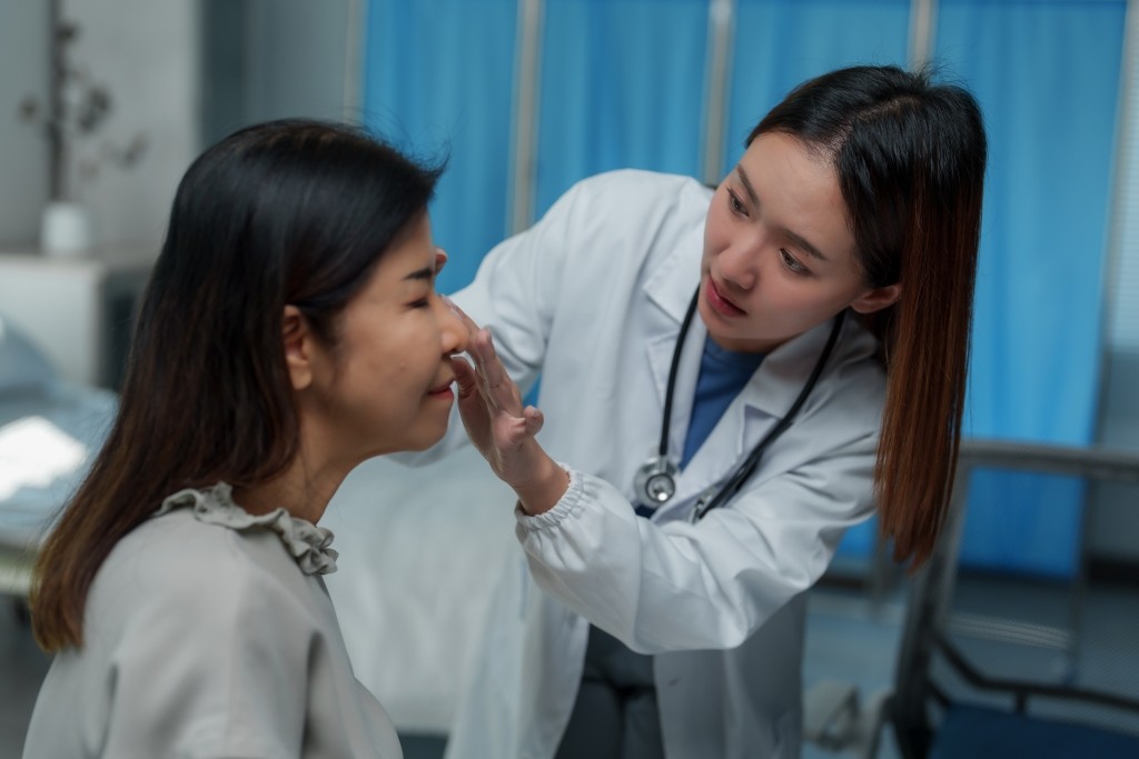 ENT Specialist Nose Examination Doctor examining a patient's nose during an ENT consultation